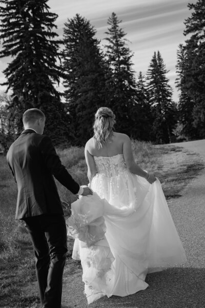 Black and white photo of a groom helping his bride