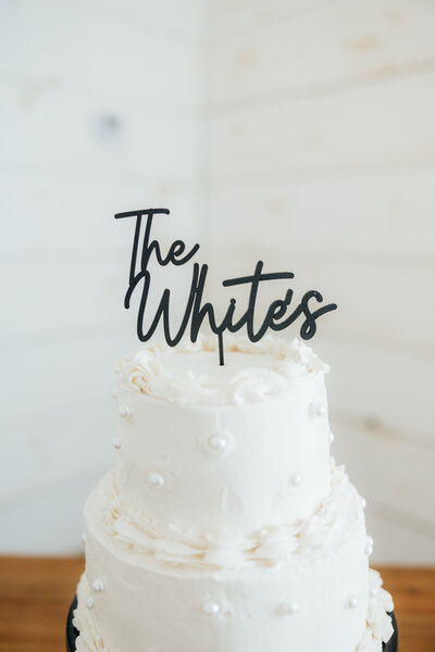 An elegant pearl wedding cake with the couple's new last name on it.