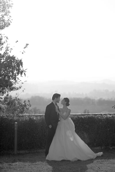 Romantic black and white portrait of bride and groom at Villa Catignano in Tuscany with scenic countryside view during golden hour