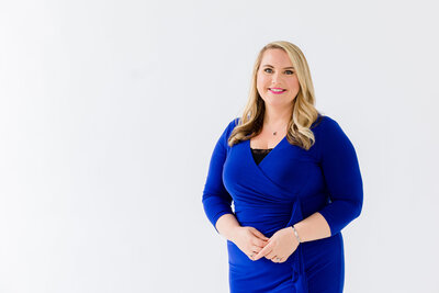 Woman in blue dress smiling at camera.