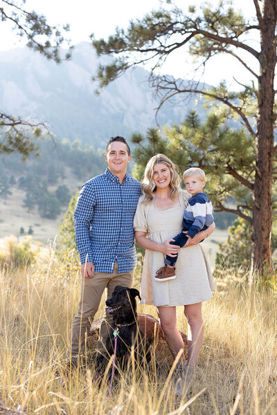 Family of three posing for a photo with their dog in Boulder Colorado
