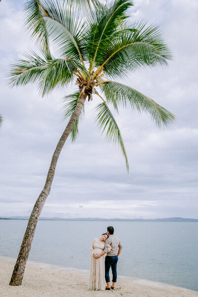 maternity couple under beach