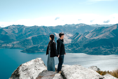 Engaged couple overlooking lake and mountain ranges in New Zealand during scenic proposal shoot, photographed by Zanthe Vorsatz.