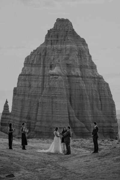 Couple elopes in Capitol Reef National Park with large monolith behind them.