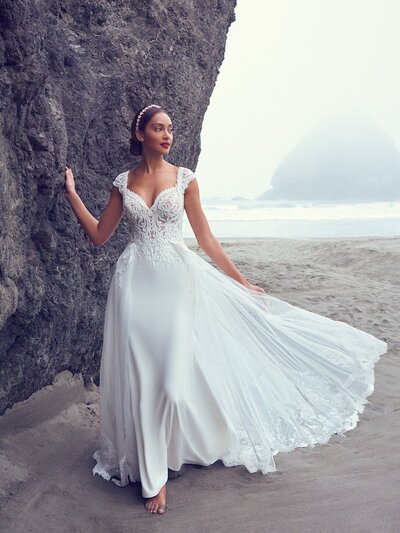 Ball Gown Wedding Dress. A breathtaking choice for the unconventional bride, this wedding dress features contrasting layers of tulle, lace motifs, and Chantilly lace. The sheer bodice features illusion long sleeves, a plunging V-neckline, and scoop back, all accented in 3D floral lace motifs. Hemline trimmed in horsehair, completing the tulle ballgown skirt. Includes detachable modesty panel option for a demurer neckline. Finished with covered buttons over zipper closure.