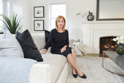 woman in black dress sittting in white living room