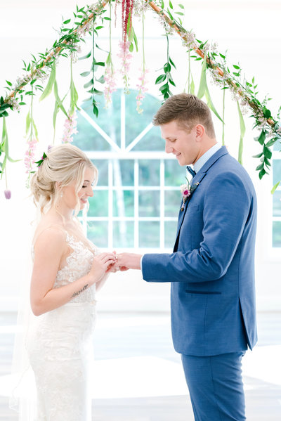 Bride slides ring on her groom's finger