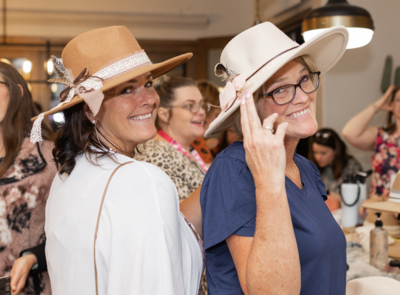 two women wearing hats and smiling
