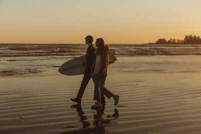 A couple enjoys a sunset  walk in Tofino BC & checks out the surf.