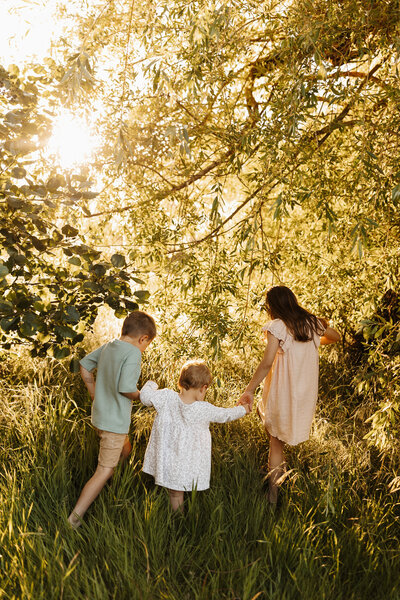 A brother and her two sisters exploring a forest during a family photoshoot in christchurch