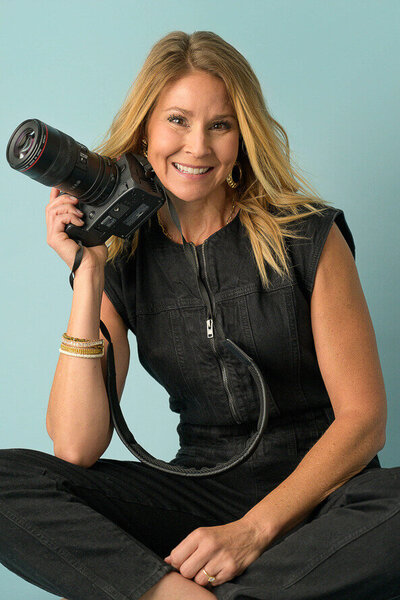 Photographer at Angela Marie Creative poses for her own headshot in her studio.
