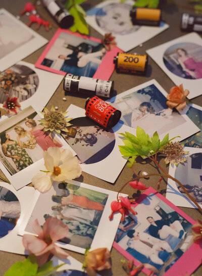 Close up of polaroids and shot film canisters with loose florals and fresh water pearls
