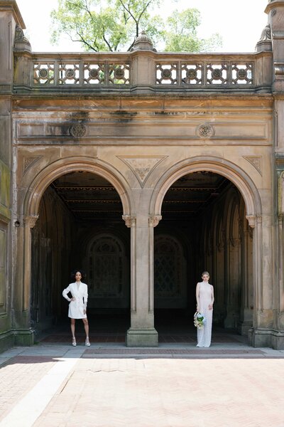 LGBTQAI+ couple pose under historic archway at Bethesda Terrace during their elopement in Central Park.