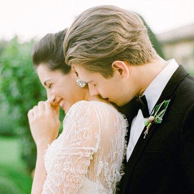 A bride and groom having a candid moment giggling