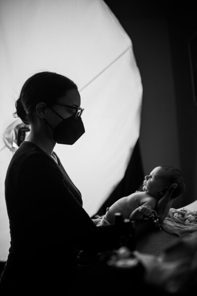 Charleston newborn photographer holding newborn baby boy during studio newborn photography session.