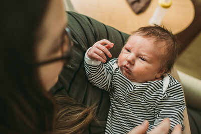 brand new baby boy looks up at mom