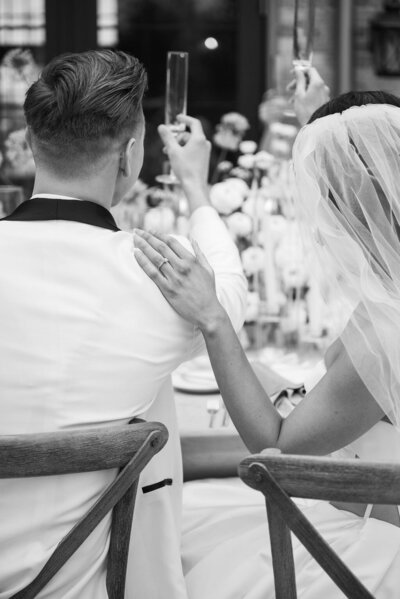 married couple raising glasses at wedding reception