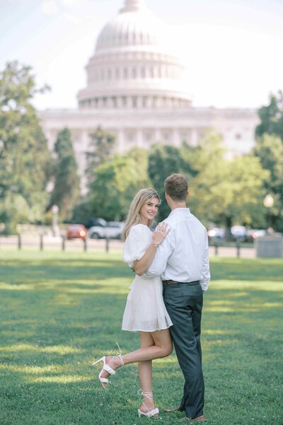 Couple holding each other while standing in front of the Capitol