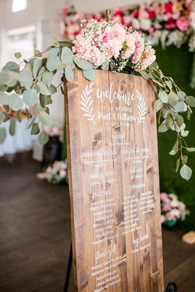 Detail photo of bride and bridesmaid holding Anemone bouquets with heavy greenery and white roses