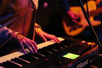 close up shot of Angela's hands playing her keys at a live show