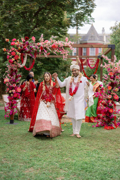 couple cheering as they exit their indian wedding ceremony at the Branch Museum