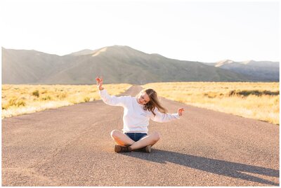 girl sitting on road in front of mountains in Las Vegas