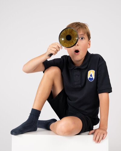 School boy with macro photo of brown iris