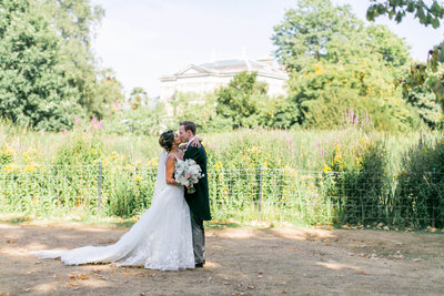 Bride and groom share a kiss in the gardens at Hampton Court House