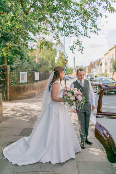 Bride and groom walk to their wedding car at their Fulham Palace wedding