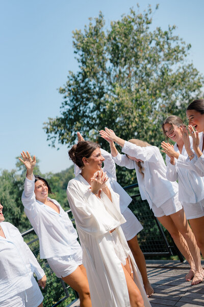 A bride and her bridesmaids dance together the morning of her wedding day in New Jersey