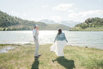 A bride twils in her wedding dress on the shore of Lake Dillon