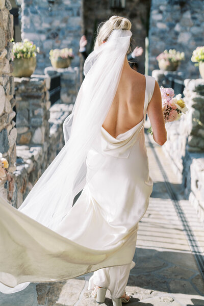 Outdoor wedding ceremony features bride at El Chorro in Scottsdale AZ surrounded by floral arrangements designed by Snapdragon Bloom Bar