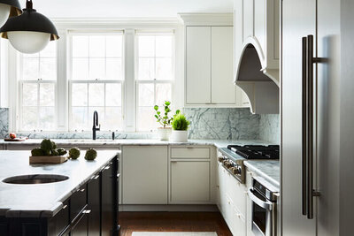 Top interior designers in Boston featured in Boston Globe Magazine. See our modern white kitchen with black island and Allied Maker pendants.