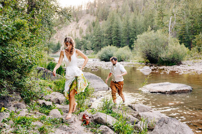 Bride and groom walking on river rock at Blackfoot River House venue in Bonner, MT