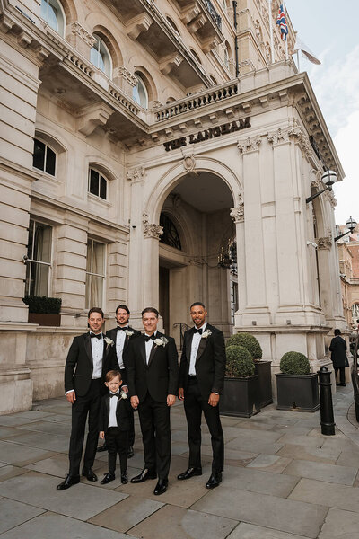 Groomsmen and small son in matching tux outfits