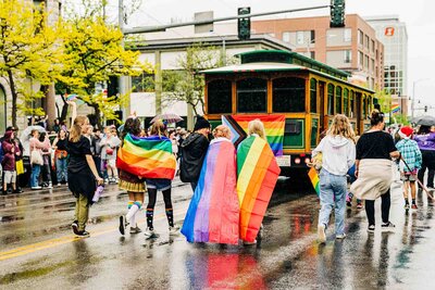 Girls walking with rainbow flags in Missoula gay pride parade