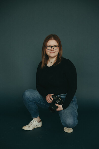 Girl squatting with a camera