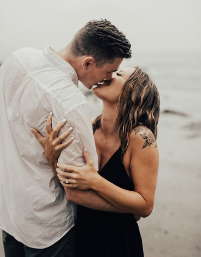 Couple kissing in the rain at  oregon coast engagement