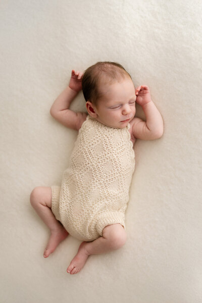 Newborn baby wrapped in soft white blanket sleeping