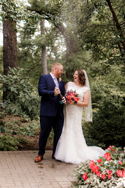 joyful couple doing champagne pop at morton arboretum fragrance garden
