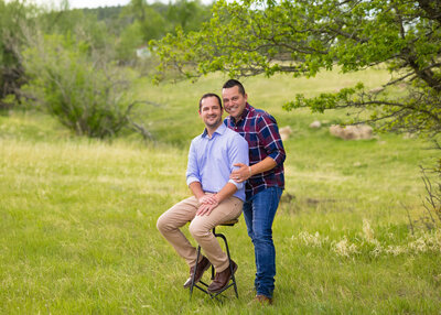 married couple sitting together in a green grassy field