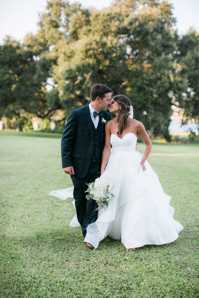 Bride and groom kiss while walking after their wedding ceremony in Wilmington NC.