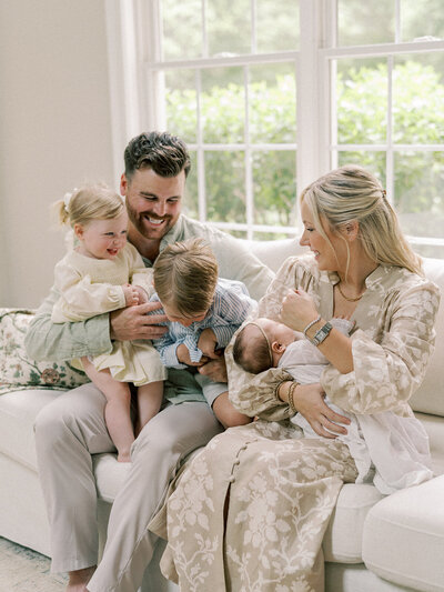 Family laughing together on couch.