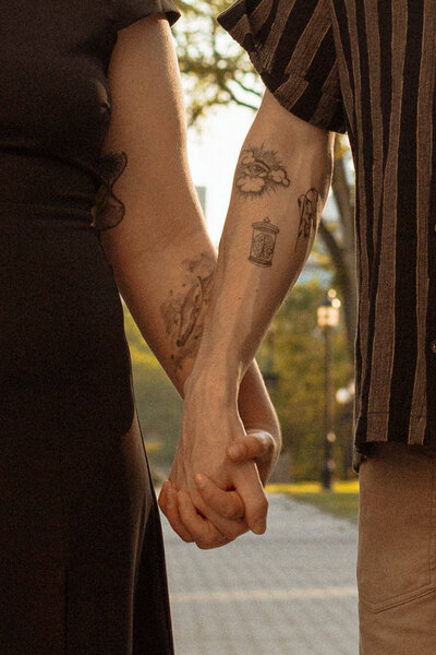 couple holding hands with tattoos 