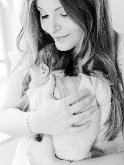 mother holding newborn by Orlando in-home newborn photographer