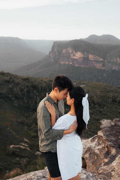 Couple standing among eucalyptus trees with Blue Mountains cliffs in the background