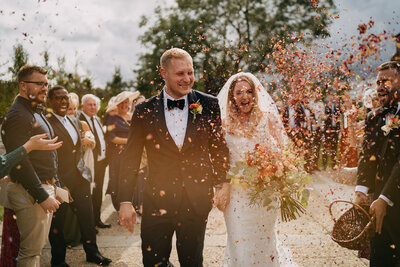 fun and colourful confetti photo of bride and groom in black tie at botley hill barn wedding