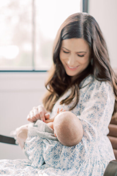 A Maryland newborn session where a mother smiles down at her baby