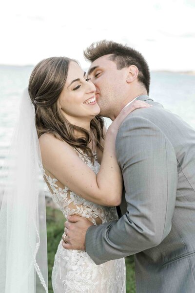 groom kissing bride on cheek