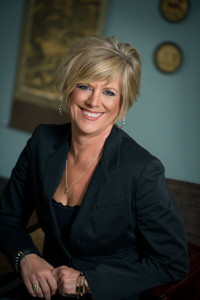 Headshot of Tara Becker, a blonde business woman with short blonde hair smiling.